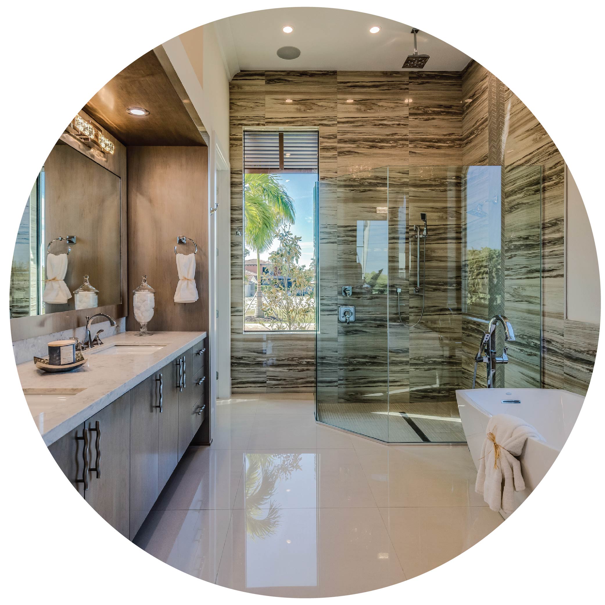 Warm toned bathroom with free standing tub, walk in shower, and brown marble wall tile