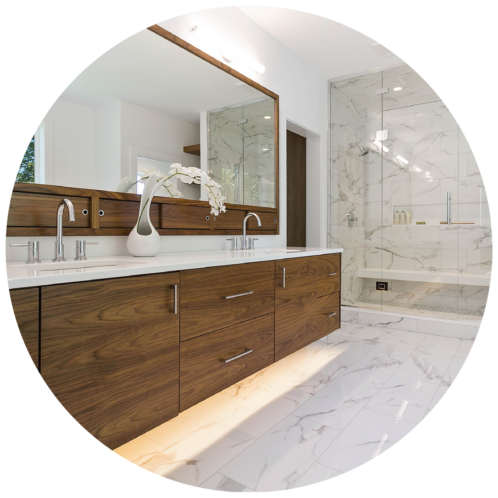 Spacious bathroom with walnut vanity and mirror featuring a walk in shower made of marble